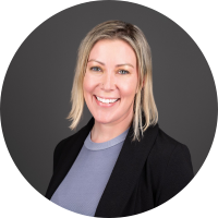 Headshot of a smiling client with blonde hair in a dark blazer