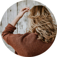 Client with long wavy blonde hair facing away from the camera
